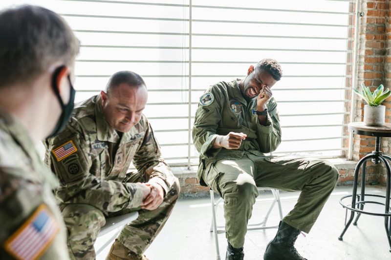 Veterans engaging in a light-hearted conversation during an indoor therapy group session.