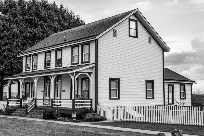 Classic wooden house with a picket fence in black and white.